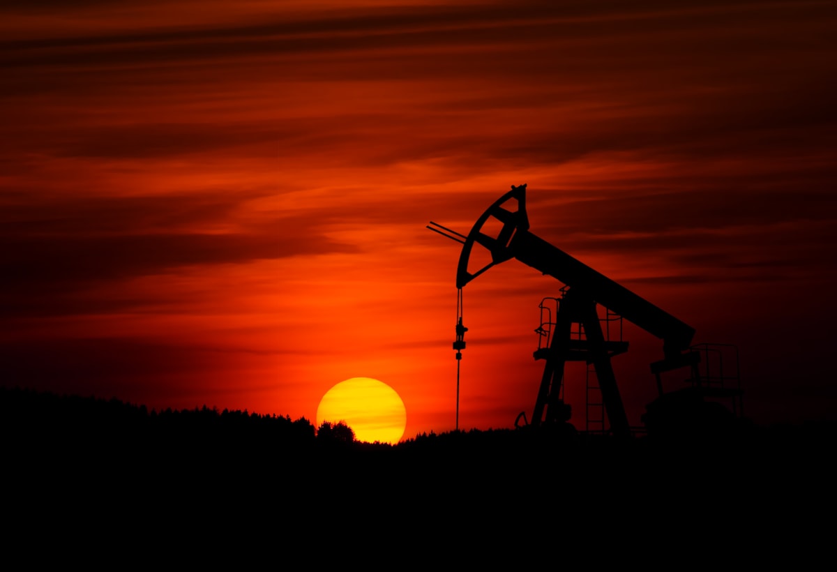 An oil refinery at sunset, reflecting the drop in crude prices